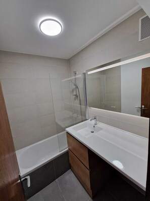 A modern bathroom with a white sink, a glass shower enclosure, and a large mirror. - Megève - 50 m² Rochebrune, 2 bedrooms (renovated in May 2024), balcony (Megève)