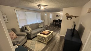 A living room with a sofa, coffee table, and a TV stand. - Peaceful Single-Level Retreat, Near Harpers Ferry,  Easy Access + Prime Location (Harpers Ferry)