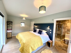 A bedroom with a bed, bedside table, and a wardrobe. - Muir Estate (Stirling)