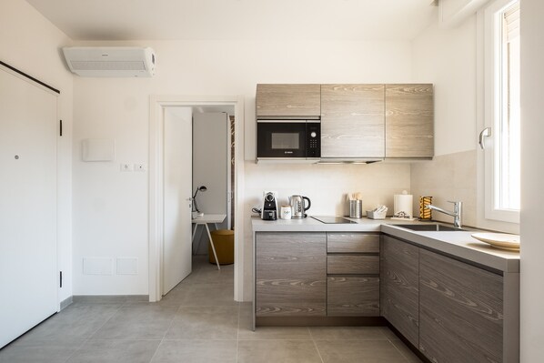 A modern kitchen with a built-in microwave, a coffee maker, and a sink. - Residenza del Reno by Wonderful Italy (Bologna)