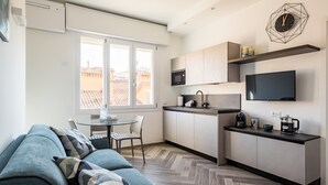Una cucina moderna con forno a microonde integrato, una macchina del caffè e un televisore a schermo piatto.