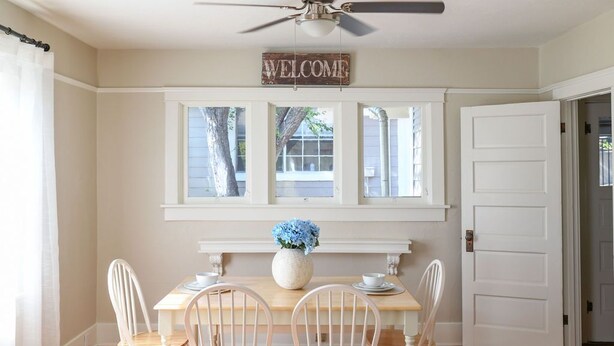 A dining area with a wooden table, white chairs, a ceiling fan, and a 'WELCOME' sign above a window. - Rose House, Two walkable blocks to Historic Downtown Prescott Courthouse (Prescott)