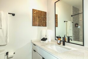 A modern bathroom with a large mirror, a white sink, and a towel rack. - Cozy Comfortable Asheville Couple's Getaway (Asheville)