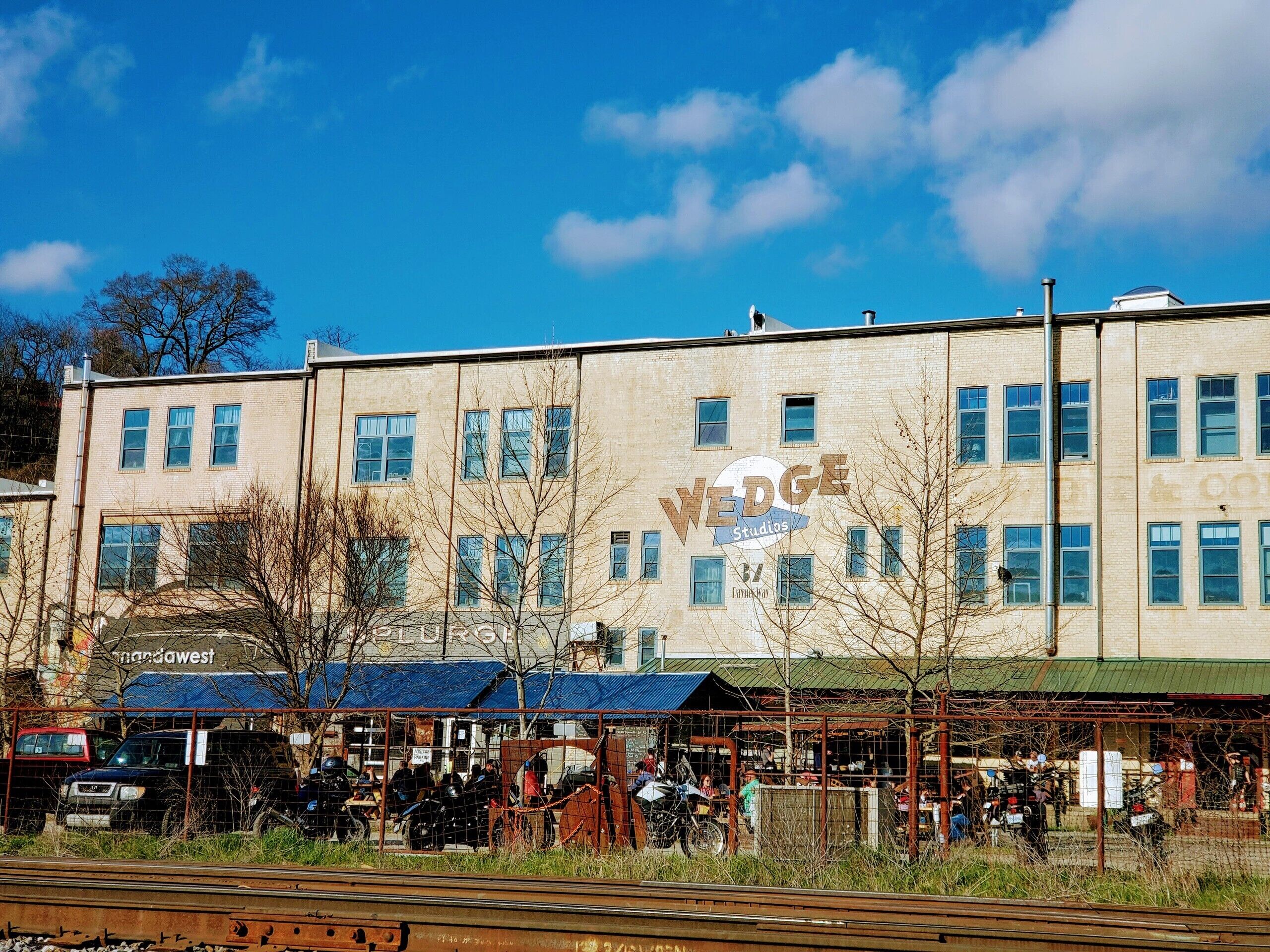 En byggnad med många fönster och en skylt med texten ”WEDGE Studios”.