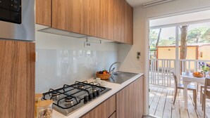 Una cocina con gabinetes de madera, una estufa a gas y un lavamanos.