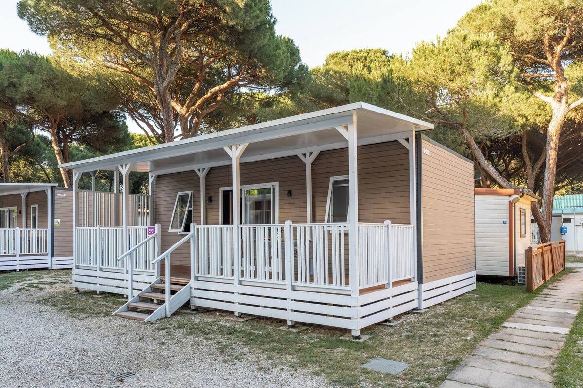 Ein Bungalow mit einer Veranda und einer kleinen Treppe zum Eingang.