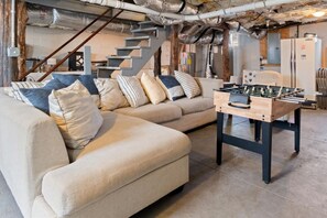 A cozy living room with a sofa, pillows, and a foosball table. - Stunning Nashville Charm - Convenient to Downtown (Nashville)