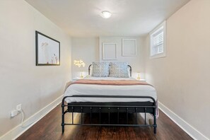 A bedroom with a bed, bedside tables, a wall-mounted light, and a framed picture. - Stunning Nashville Charm - Convenient to Downtown (Nashville)