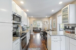 A modern kitchen with white cabinets, stainless steel appliances, and a granite countertop. - Stunning Nashville Charm - Convenient to Downtown (Nashville)