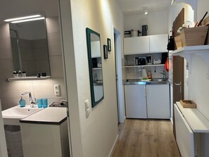 A compact kitchen with a sink, countertop, and cabinets. - Lüttjer Kiwitt - perfect location for short distances and relaxing days (Wangerooge)