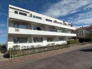 A multi-story building with a flat facade, balconies, and a visible sign indicating it is a hotel. - Lüttjer Kiwitt - perfect location for short distances and relaxing days (Wangerooge)