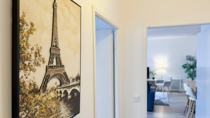 A hallway with a framed picture of the Eiffel Tower, leading to a dining area with a table and chairs. - ★ Cosy Apartment Near Disneyland Paris ★ (Serris)