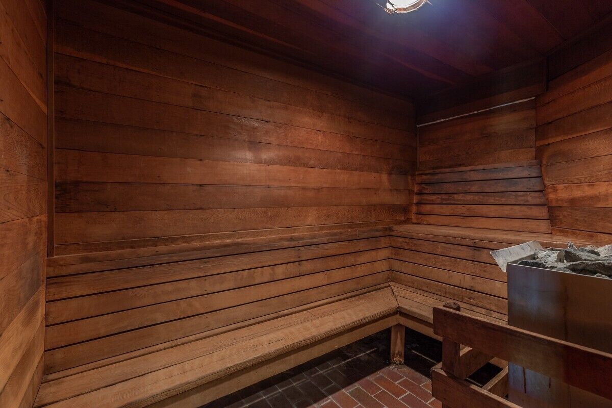 Eine Holzsauna mit einer Bank und einem Steinkamin.