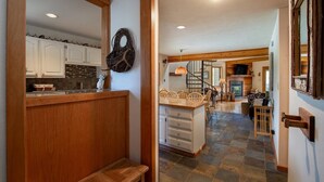 A spacious kitchen with white cabinets, a wooden bench, and a stone-tiled floor. - Silverthorn Skiing & Hiking with Community pool/hot tub/Sauna. (Silverthorne)
