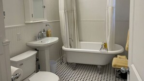 Une salle de bain avec des toilettes, un lavabo et une baignoire.