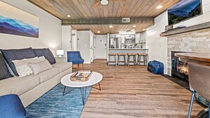 A modern living room with a sofa, coffee table, and a fireplace. - Mountain-View Condo w/ Pool & Hot Tub Access (Gatlinburg)