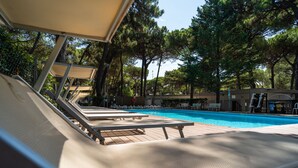 Ein Poolbereich mit Liegestühlen und einer Holzterrasse.