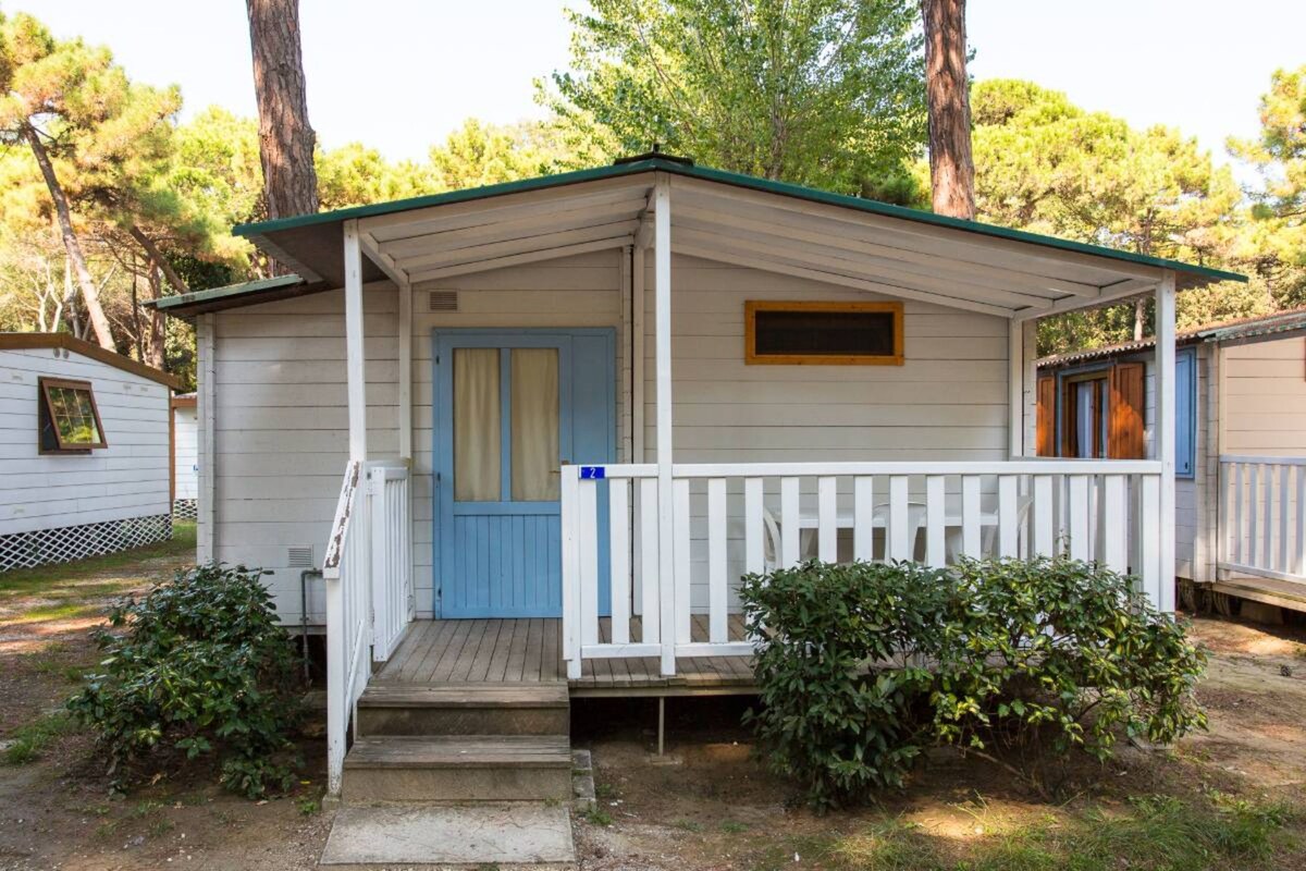 A small, single-story cabin with a porch, a door, and a window.