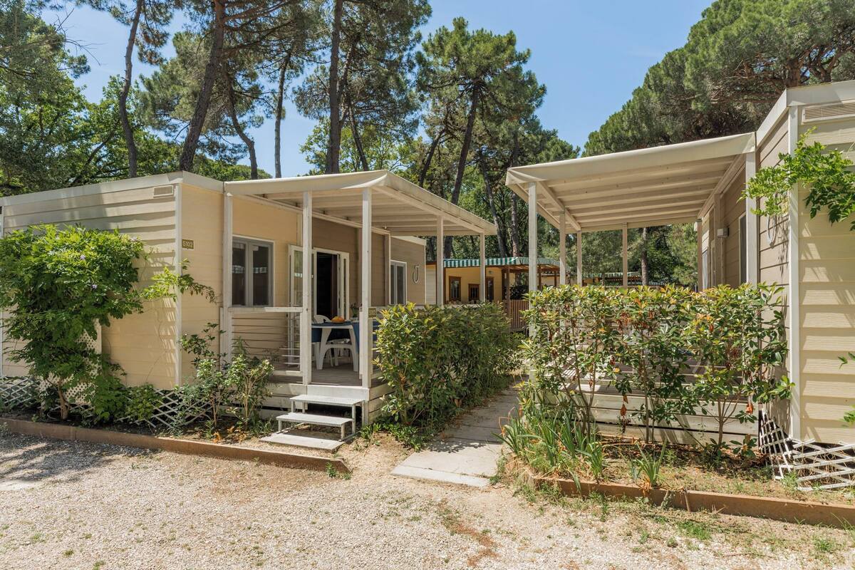 A row of mobile homes with covered porches and a gravel pathway.