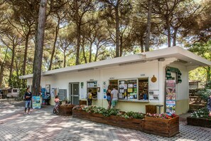 A rustic outdoor café with wooden planters and a menu board. - Club Del Sole Marina Romea Easy Camping Village (Ravenna)