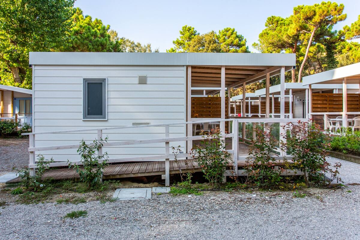 A modern, single-story building with a covered outdoor area and a wooden deck.