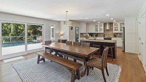 A spacious kitchen with white cabinets, a stone backsplash, and a large island. - Kiawah Home with Private Salwater POOL & Short Walk to Beach! (Kiawah Island)