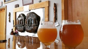 Un bar con dos vasos de cerveza, una pizarra con 'Welcome' y 'Suntownsales' escritos, y decoración de madera.