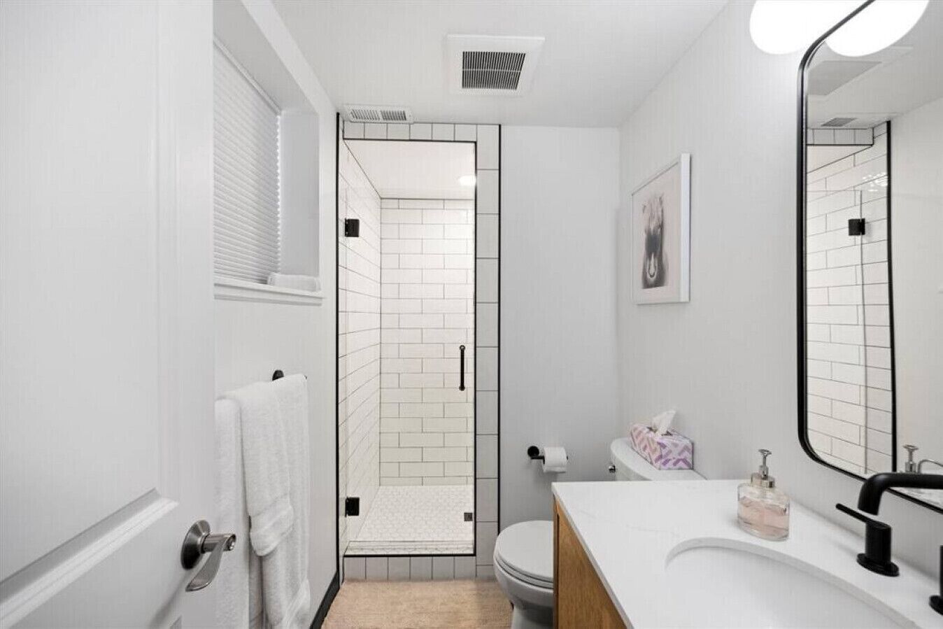 A modern bathroom with a shower, toilet, and sink.