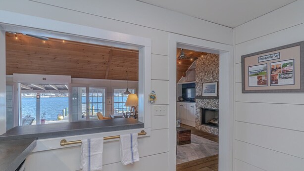 Eine moderne Küche mit Meerblick, einem Kamin und einem gerahmten Bild von der Chesapeake Bay.