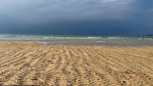 A sandy beach with footprints and a distant island. - Fisherman's Cottage, a haven in Padstow old town (Padstow)