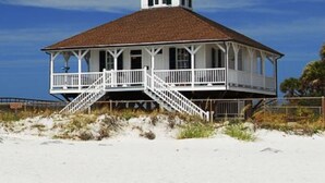 A white building with a brown roof and a tower, situated on a sandy beach with a clear blue sky. - Historic MamaDear House, Boca Grande Island w/private pool, 5min stroll to beach (Boca Grande)