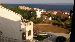 A coastal town with buildings, a road, and a car.