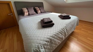 A bedroom with a bed, pillows, and folded towels. - Room in Zaton (Zadar) with WIFI, Washing machine (4141-9) (Nin)