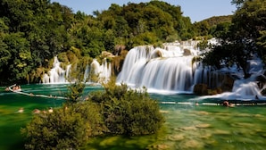 A waterfall cascading into a turquoise pool surrounded by lush greenery. - Room in Vodice with Balcony, Air condition, WIFI (4826-1) (Vodice)