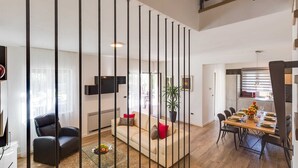 A modern living room with a sofa, a dining area with a table set for four, and a kitchen area with a refrigerator and oven. - Villa Lyan with Swimming Pool (Tar Vabriga)