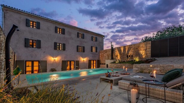 A poolside area with a pool, outdoor furniture, and a stone wall. - Villa Ferna with Pool (Golaš)