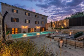 A poolside area with a pool, outdoor furniture, and a stone wall. - Villa Ferna with Pool (Golaš)