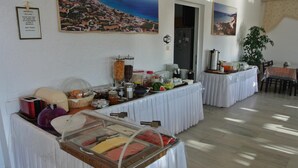 Un bufé con diversos alimentos y vistas a un pueblo costero.