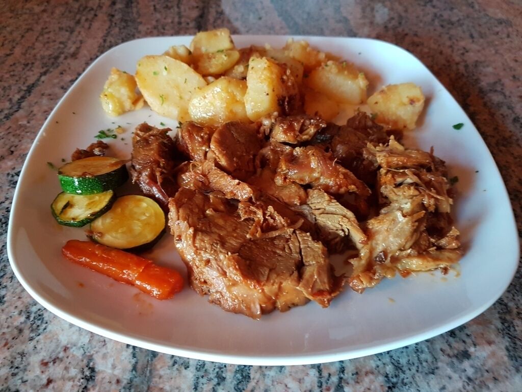 Un plat amb carn desfilada, patates, carabassa i un raigunya.