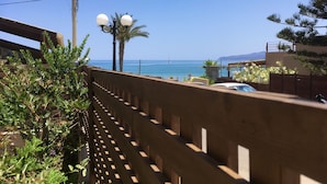 Une vue sur la côte, avec une clôture en bois, un lampadaire et une voiture garée au loin.