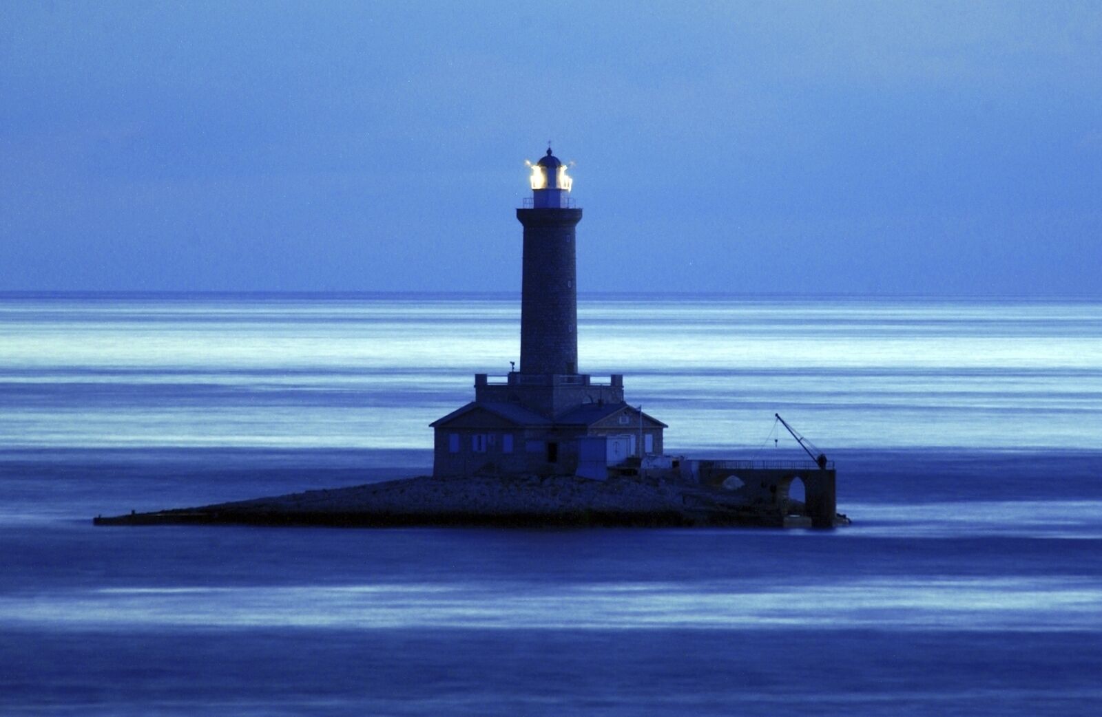 Ein Leuchtturm auf einer kleinen Insel mit freiem Blick auf das Wasser.