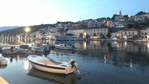 A marina with boats docked, a town in the background, and a clear sky.