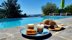 A poolside setting with a clear view of a bridge, a wicker basket, and a plate with two drinks and cookies. - Holiday Home in Split with Seaview, Terrace, Air condition, WIFI (4937-1) (Split)
