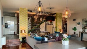 A modern living room with a sofa, coffee table, and a dining area. There is a staircase leading to an upper level. - Holiday Home in Split with Seaview, Terrace, Air condition, WIFI (4937-1) (Split)
