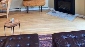 A living room with a wooden spiral staircase, a flat-screen TV, a fireplace, and leather sofas. - Clean, quiet and cozy mountain get away Condo (Bartlett,)