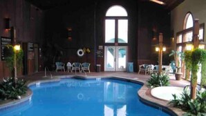 An indoor swimming pool with a clear view of the pool area, including the pool's edge, a ladder, and surrounding seating areas. - Clean, quiet and cozy mountain get away Condo (Bartlett,)
