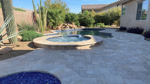 A landscaped outdoor area with a hot tub, a swimming pool, and various desert plants. - Desert Oasis with pool and spa in gated community (Laveen)