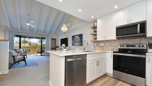 Cocina moderna con armarios blancos, electrodomésticos de acero inoxidable y una isla grande.