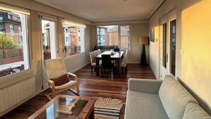 A spacious living area with a sofa, a coffee table, and a dining table set for four. - "Amaluz Ocean Villa Bilbao Beach for families and groups of friends". (Getxo)