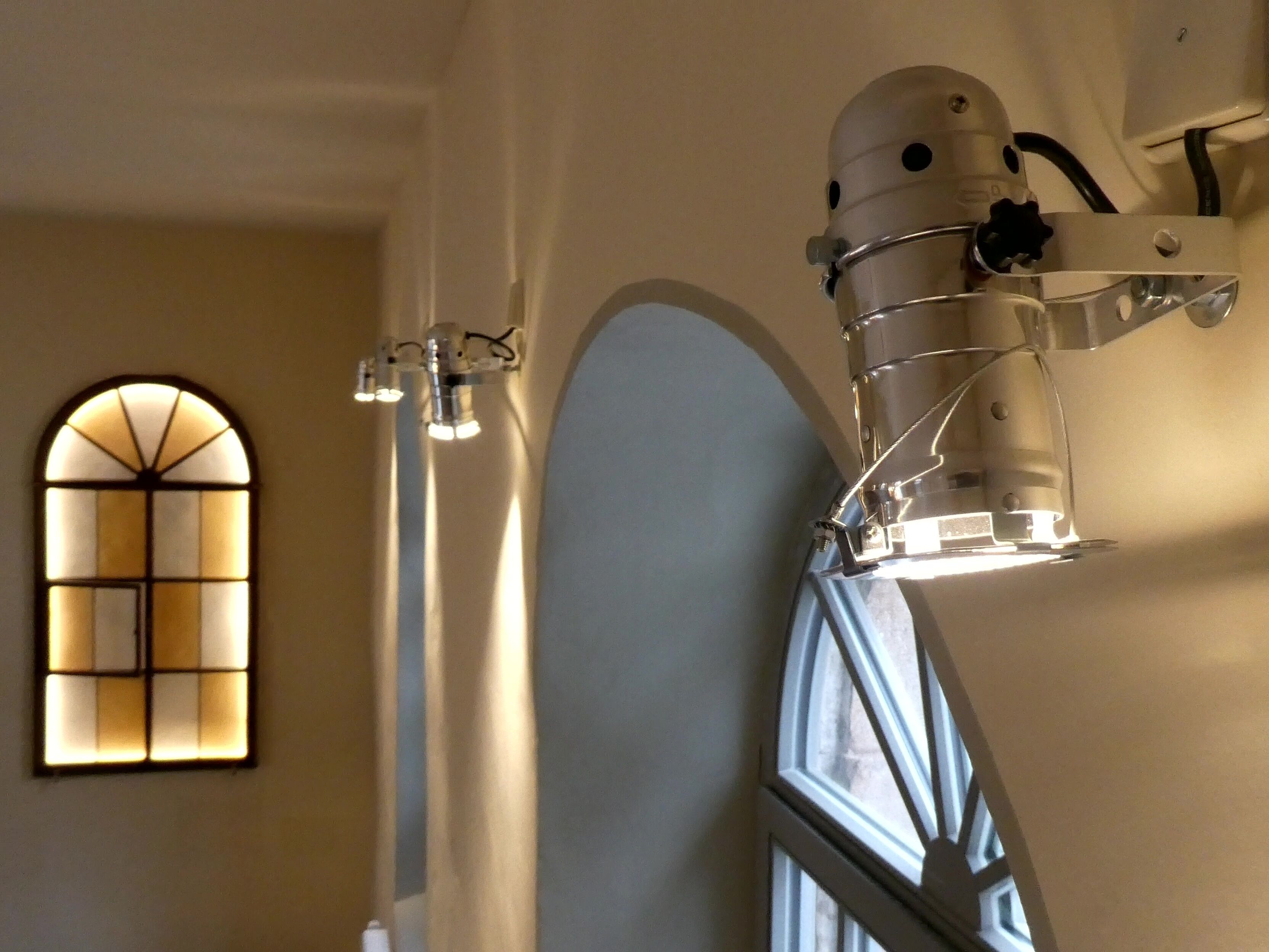 A modern interior with a unique spherical light fixture and a stained glass window.